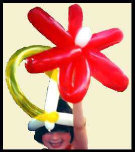 Girl smiles in delight wearing balloon twisted hat at her birthday party in Bronx NYC