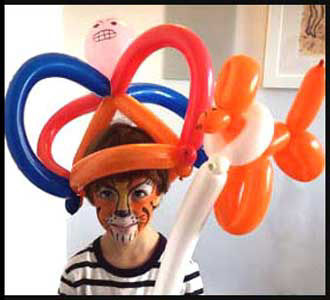 Birthday boy wears balloon twisted crown & holds balloon puppy at his kids party in Manhattan NY