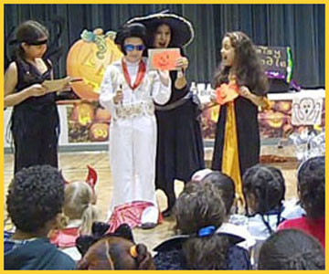 Kids draw and show off their drawings of pumpkin faces at Halloween magic show in Long Island NY